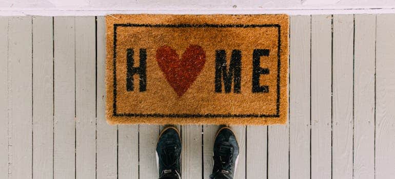 two feet in front of the doormat sign that says home